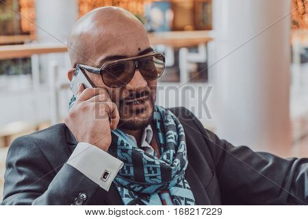 Arab businessman talking on mobile phone at a shopping center