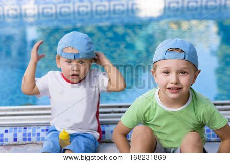 Two adorable siblings. Big brother not happy with his little brother. Cute kids playing together on sunny warm summer day. Brother love relationship