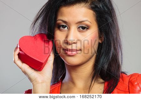 Valentines Day concept. Lovely cute african girl in stylish red jacket holding heart box gift present. Love time.