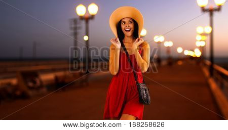 Young White Girl Standing On The Pier In A Red Sun Dress And Floppy Hat