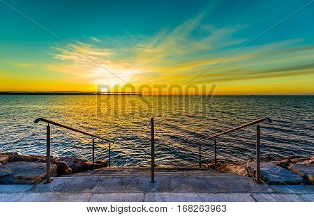 Steps On A Beach With Sunset On The Ocean Sea.