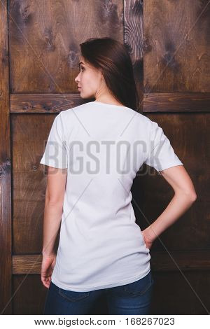 Young woman wearing blank white t-shirt with area for your logo or design, mock-up of template white t-shirt, back view