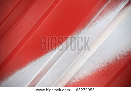 Close up of white painted line on red metal background. Red steel container wall with white line closeup. Red ribbed transportation container wall.