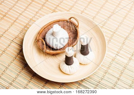 Massage bundles on a plate on bamboo mat. Spa, health, treatment, concept.