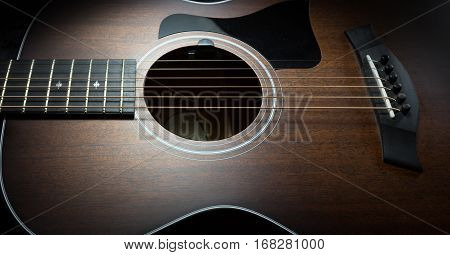 Acoustic guitar on a dark lit background