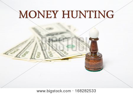 Chess Bishop Figure and dollars with message MONEY HUNTING
