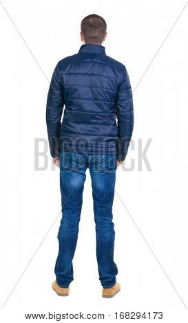 Back view of handsome man in blue windcheater looking. Standing young guy in jeans. Rear view people collection.  backside view of person.  Isolated over white background.