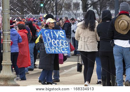 WASHINGTON DC - JANUARY 20: Woman carries peace sgn during inauguration of Donald Trump. Taken January 20 2017 in District of Columbia.