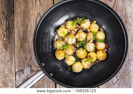 Fried potato dumplings with bacon in frying pan. Studio Photo