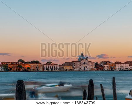 Grand canal in Venice during beautiful  sunset with a moving blurry boat and clouds on background