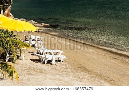 Yellow parasol and recliners on the beach in Subic bay Philippines