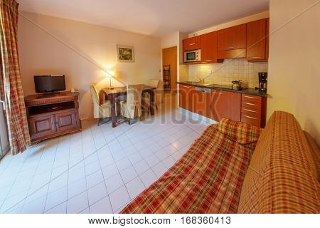 SAINT-TROPEZ, FRANCE - AUG 2, 2016: Interior of hotel room, view of kitchen and living room with television set