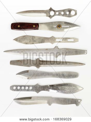 Collection of used throwing knives on white background