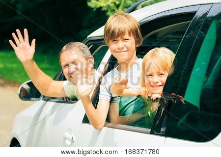 family sitting in their car, leaving for holidays