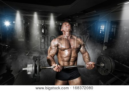 Athlete Muscular Bodybuilder In The Gym Training With Bar