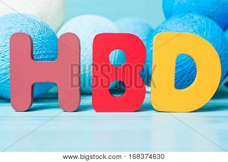 Colorful happy birthday words with garland on blue wooden background