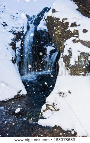 Small waterfall during heavy snow at blue hour, mountain Kozomor, Serbia