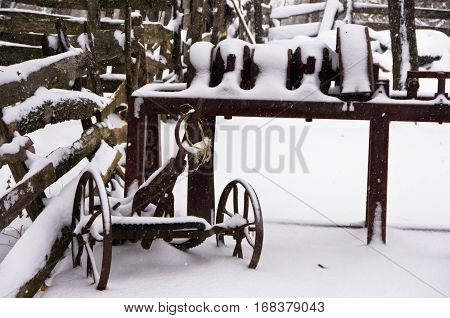 Old rusty farm equipment covered with snow at winter, mountain Kozomor, Serbia