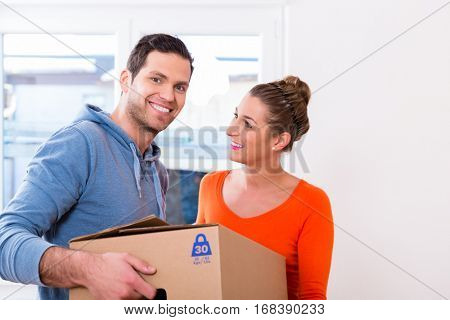 Couple, woman and man, moving house carrying packing cases