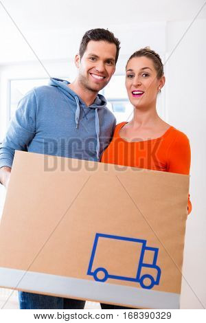 Couple, woman and man, moving house carrying packing cases