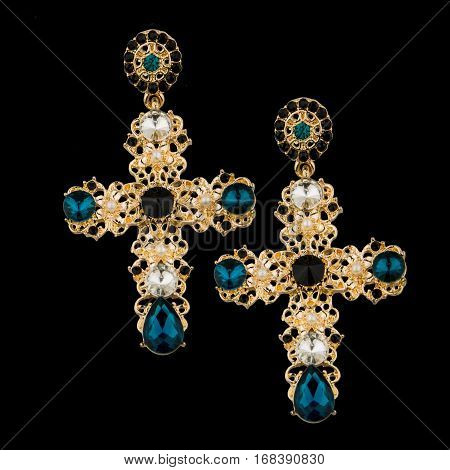 golden earring with sapphire on black background
