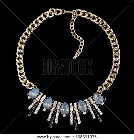 Golden necklace with sapphire and diamonds  on black background
