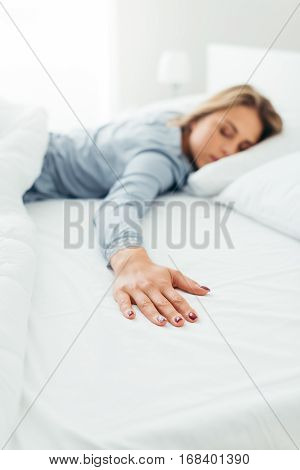 Lonely young woman sleeping in her bed and missing her partner she wants to hug him but he is not there