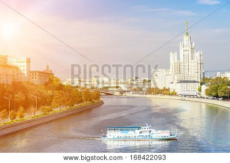 Kotelnicheskaya embankment with leisure boat floating across the Moscow river on a sunny day