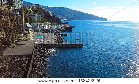 Coastal rocky line of hotels in Funchal the mountains the ocean. Madeira Portugal