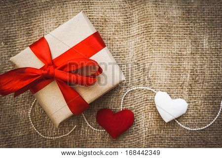 Gift box with red ribbon as a hand made gift for a Valentine`s day