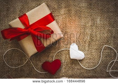 Gift box with red ribbon as a hand made gift for a Valentine`s day