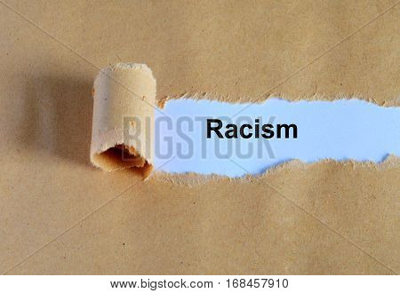 Racism Word Written Under Ripped And Torn Paper.