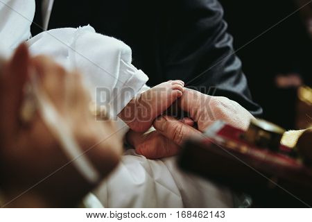 Christening Of Little Baby In Church, Close-up Feet And Priest Hand