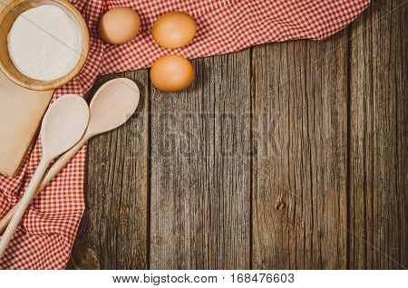 Baking or cooking ingredients background. Top view photograph with kitchen utensils on vintage, natural, raw, wooden background with visible texture.
