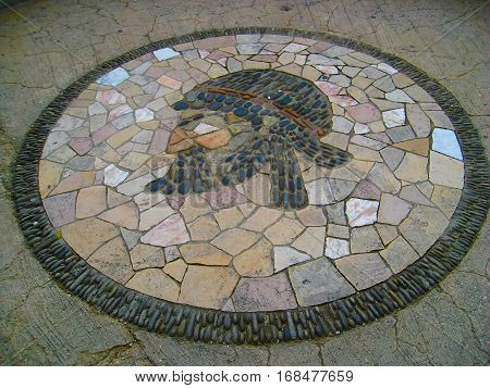 Beautiful large patterned pebble stone mosaic arranged in a symbol on pavement pedestrian street in Nice Cote d'Azur France