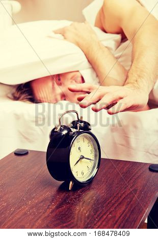 Man trying to sleep, when alarm clock ringing