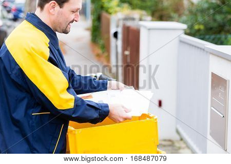 Postman delivering letters to mailbox of recipient