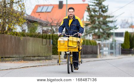 Postman riding his cargo bike carrying out mail in neighborhood