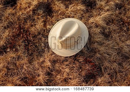 old boho or cowboy hat on grass at sunset in mountains travel concept space for text
