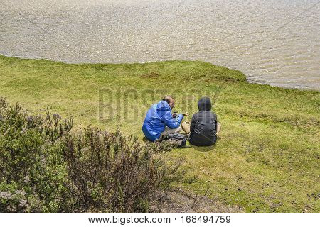 COTOPAXI, ECUADOR, FEBRUARY - 2016 - Couple talking at shore of lake in Cotopaxi national park Ecuador