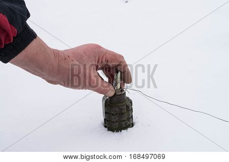 Hand sets the Soviet anti-personnel mine in the snow
