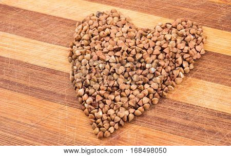 Heartt from buckwheat on a wooden background is a very useful cereal