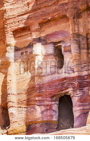 Multi Colored Red Rock Tomb Petra Jordan. Built by the Nabataens in 200 BC to 400 AD. Rose Red canyon walls create many abstracts close up. Inside the Tombs the rose red can become blood red. Reds are created by magnesium in sandstone.