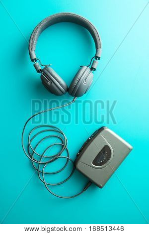 The vintage audio player and headphones on blue background. Top view.