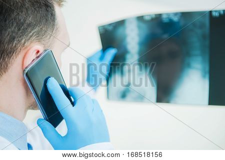 Medical Doctor Consulting Xray Imagery Results by Phone. Healthcare Photo Concept.