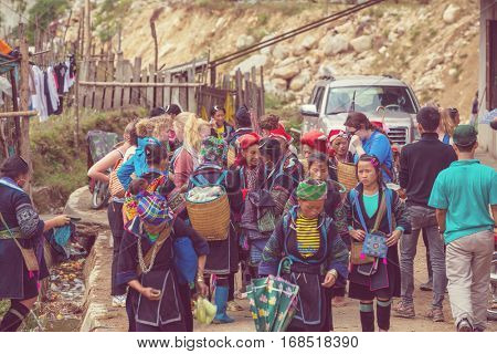 SAPA, VIETNAM - OCTOBER 29, 2012: Hmong women sell souvenirs in Sapa. The Hmongs are known for their colorful clothes and silver jewelry. Hmong women have various clothes colours and style