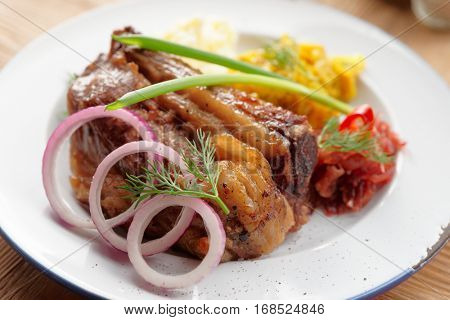 Grilled pork ribs with sauerkraut and mashed potatoes on restaurant table