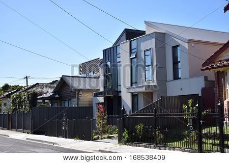 suburban streetscape of modern houses against blue sky