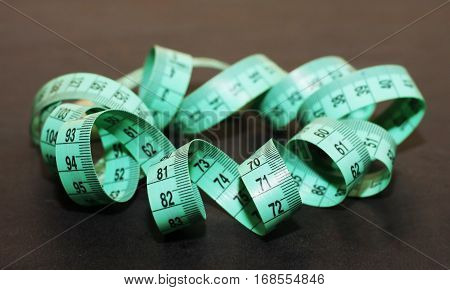 green tape measure on black background, tool