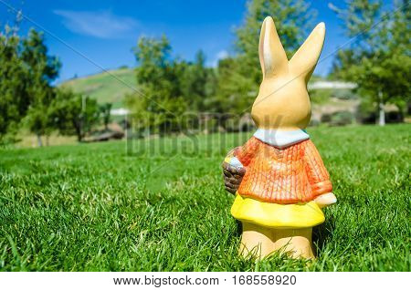 Easter bunny waith basket and color eggs in field - American landscape